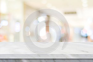 Empty white table top, counter, desk over blur perspective store with bokeh light background, White marble stone table, shelf and