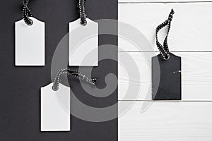 Empty white tags in a row on white and black wooden background. Top view. Mock up sample. Blank price tag on wooden planks. Design