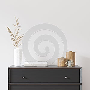 Empty white wall with black dresser, white vase and wood decor.