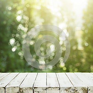 Empty white wood table top on blur tree garden in morning