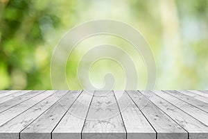 Empty white wood table top on nature green blurred background,space for montage show products