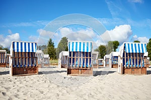 Empty wicker beach chairs on sand