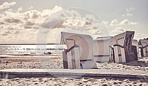 Empty wicker beach chairs on a beach at sunset