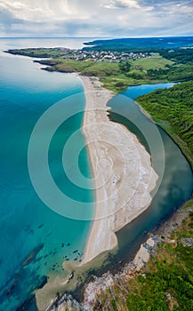 An empty wild beach, surrounded by rocks and green forests