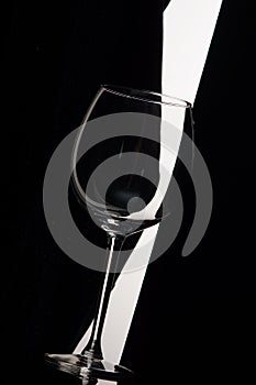 Empty wine glass bent over black and white background