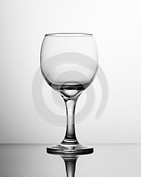 Empty wine glass black and white. Photo of a single round glass wine glass