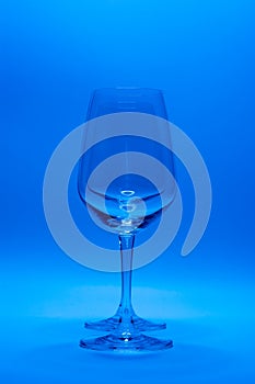 Empty clean wine glass on blue background