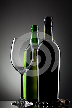 Empty wine glass and bottles
