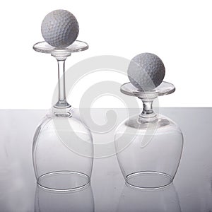 Empty wine glass with golf ball
