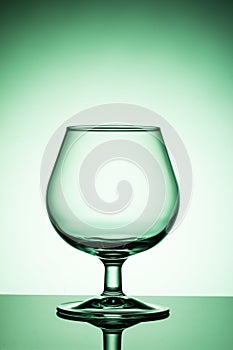 Empty wine glass on a green background