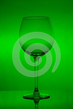 Empty wine glass on green background, empty wineglass