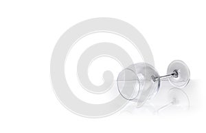 Empty wine glass lies on glass on white background