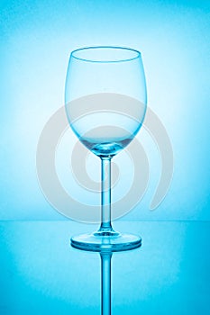 Empty wine glass with reflection in blue light