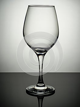 An empty wine glass stands on a gray table