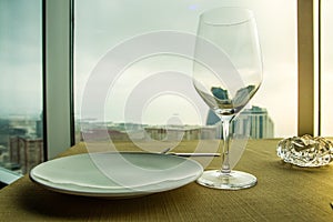 Empty wine glass on the table in front of a window