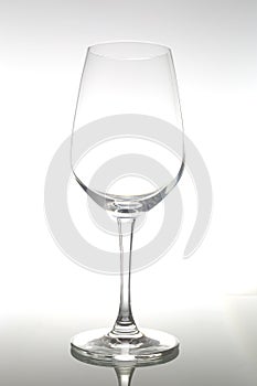 Empty wine glass on glass table. Empty glass on white background