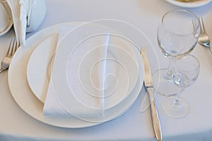 empty wine glasses on a round table with a white tablecloth.