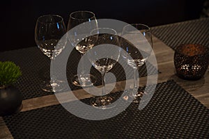 Empty wine, water, juice glasses on bar, bar interior, equipment for parties in dark light