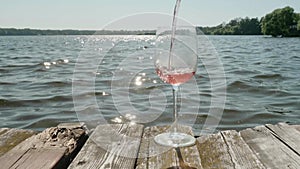 Empty wineglass on wooden panel of old pier. Steam appears on glass because of tea poored into it