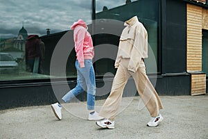 Empty woman clothes walk on street wearing hoody, jeans trousers, sneakers and colorful trainers.