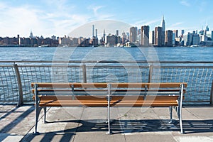 Empty Bench at a Park in Greenpoint Brooklyn New York looking out towards the East River and the Manhattan Skyline photo