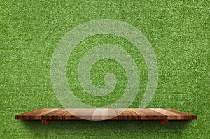 Empty wood board shelf at fake green grass wall background,Mock