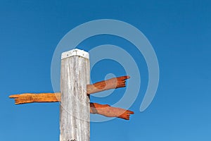 Wood carved direction signs on a beach pole