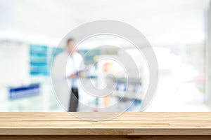 Empty wood counter top on blur pharmacy background