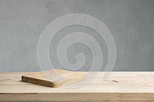 Empty of wood cutting board on table top on cement wall background.For montage product display