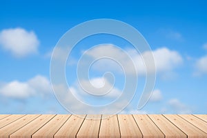 Empty wood plank table top with blue sky and clouds with blur background - For product display.