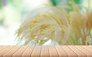 Empty wood plank table top with yellow Rice husk or grains with blur background.