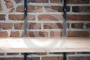 Empty wood shelf on old brick wall background, grunge industrial interior background texture