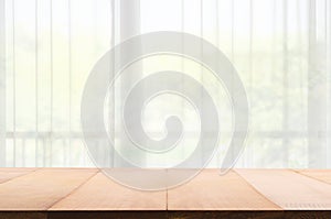 Empty of wood table with Blur of curtain window from green garden view in morning background