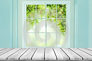 Empty wood table with blur window on green bokeh background.