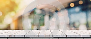 Empty wood table and blurred light table in coffee shop and cafe with bokeh background. product display template