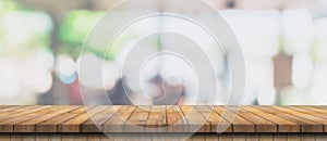 Empty wood table and blurred light table in coffee shop and cafe with bokeh background. product display template