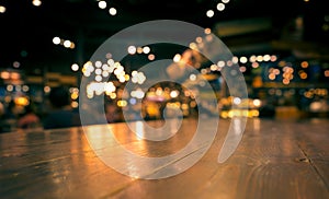 Empty wood table top bar on blur cafe restaurant in dark background