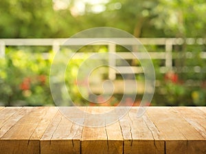 Empty wood table top on blur abstract garden and house background