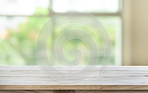 Empty wood table top on blur abstract green garden from window