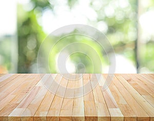 Empty wood table top on blur abstract green garden from window view background