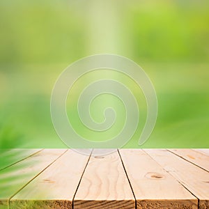 Empty wood table top on blur abstract green garden from window view