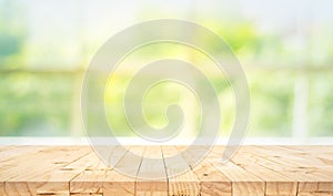 Empty wood table top on blur abstract green garden from window view in the morning. For montage product display or design key