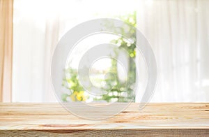 Empty of wood table top on blur of curtain window and garden