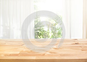 Empty of wood table top on blur of curtain with window view green from garden background