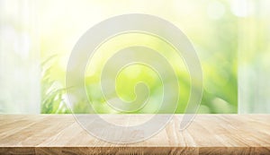 Empty of wood table top on blur of curtain with window view green from tree garden background