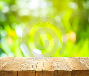 Empty of wood table top on blur of fresh green abstract