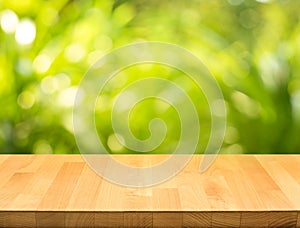 Empty of wood table top on blur of fresh green abstract from garden