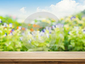 Empty of wood table top on blur of fresh green abstract from garden