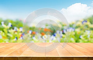 Empty of wood table top on blur of fresh green garden