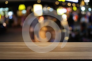 Empty wood table top and blur of night market background/selective focus .For montage product display.